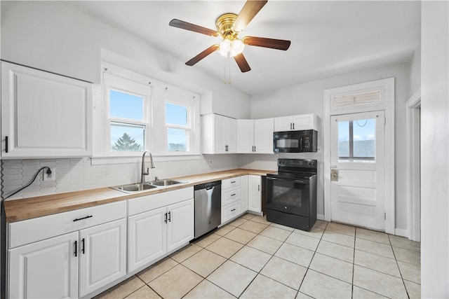 kitchen with a sink, a healthy amount of sunlight, black appliances, wooden counters, and backsplash