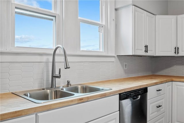 kitchen featuring butcher block counters, white cabinetry, dishwasher, and a sink