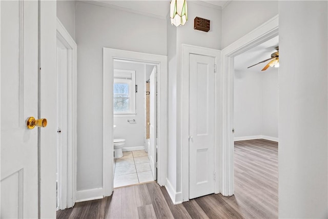 corridor with wood finished floors and baseboards