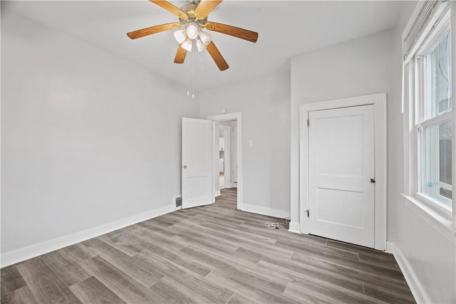 unfurnished bedroom with a ceiling fan, baseboards, and wood finished floors