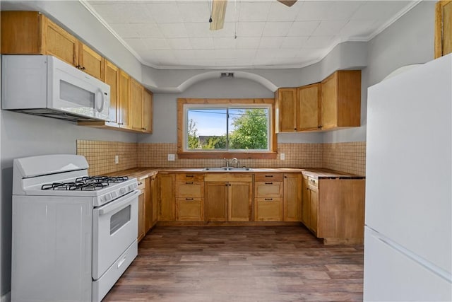 kitchen with white appliances, dark wood-style flooring, a sink, light countertops, and tasteful backsplash