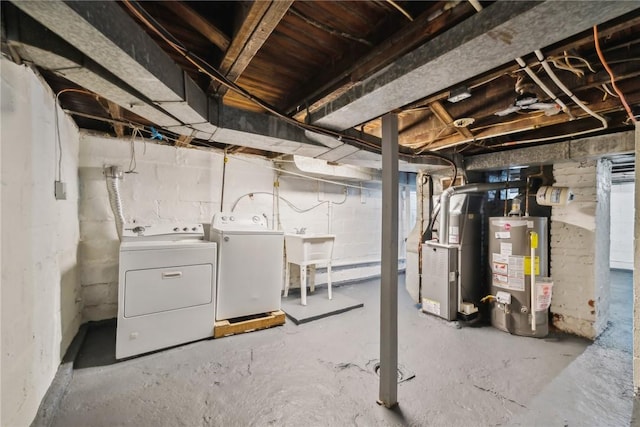 unfinished below grade area with gas water heater, heating unit, and separate washer and dryer