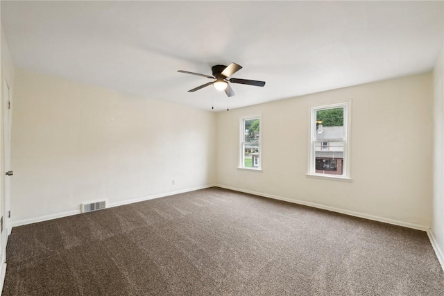 spare room featuring ceiling fan, carpet, visible vents, and baseboards