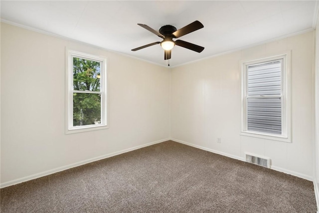 carpeted empty room with visible vents, baseboards, a ceiling fan, and crown molding