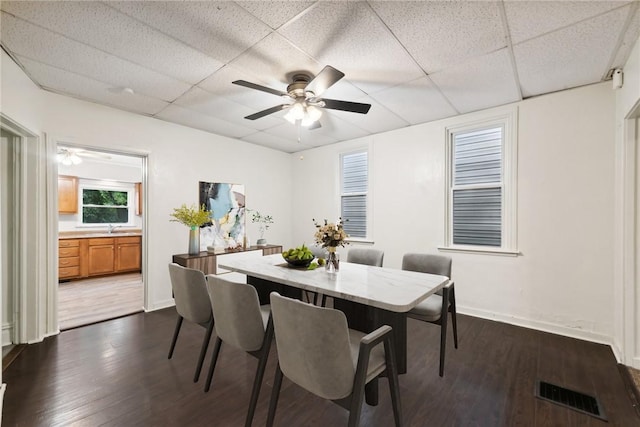 dining room featuring baseboards, dark wood-style floors, visible vents, and a paneled ceiling