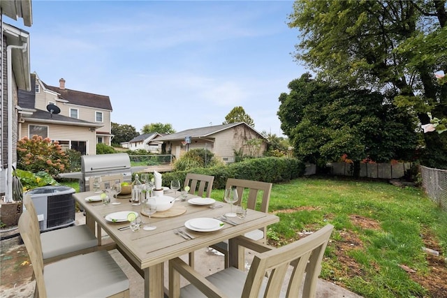 view of patio with grilling area, cooling unit, outdoor dining area, and fence