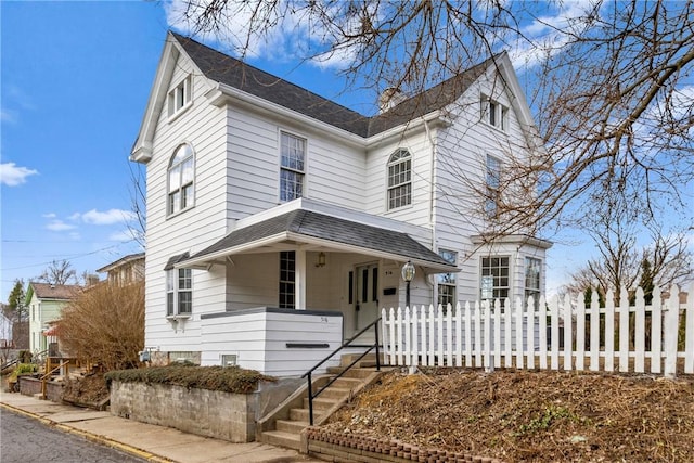 view of front of property featuring a shingled roof and fence