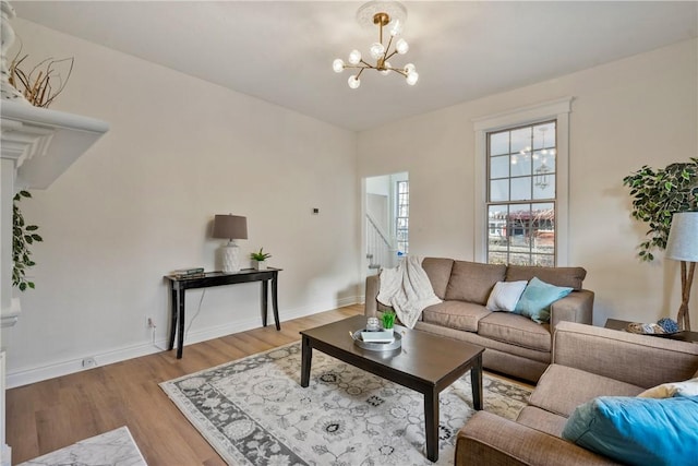 living room with a chandelier, stairway, wood finished floors, and baseboards