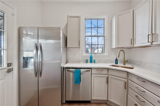 kitchen with stainless steel appliances, light countertops, and a sink