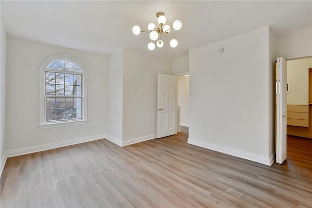 unfurnished dining area with a chandelier, baseboards, and wood finished floors