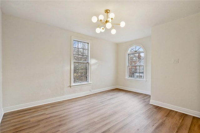 interior space featuring baseboards, a chandelier, and wood finished floors