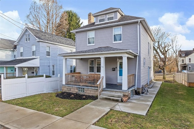 traditional style home featuring a porch, a front yard, and fence