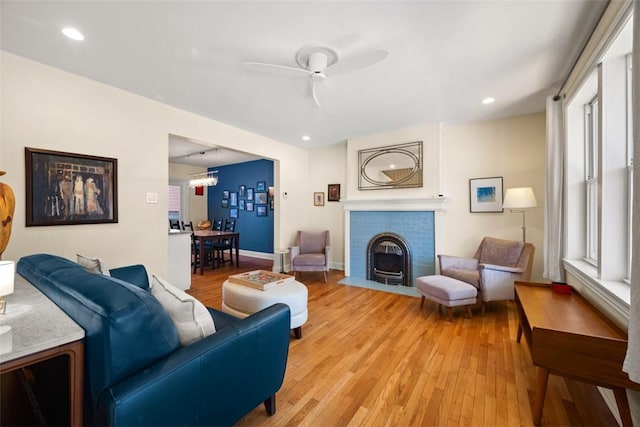 living area with light wood-type flooring, baseboards, a ceiling fan, and recessed lighting