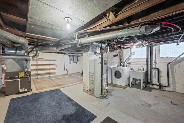 basement featuring gas water heater, a sink, electric panel, heating unit, and washing machine and clothes dryer