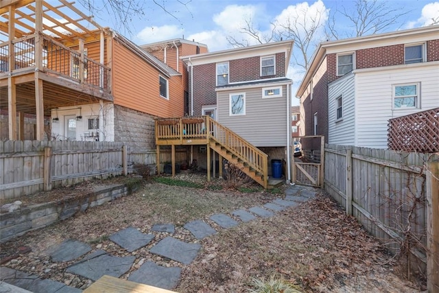 back of house featuring a fenced backyard, stairs, a gate, and a wooden deck