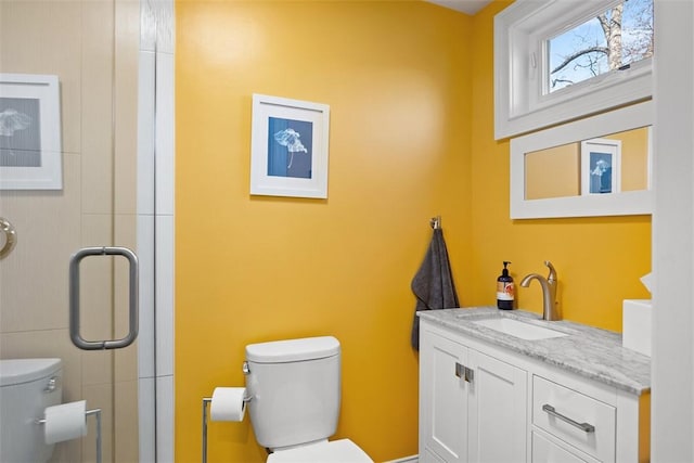 full bath featuring a stall shower, vanity, and toilet