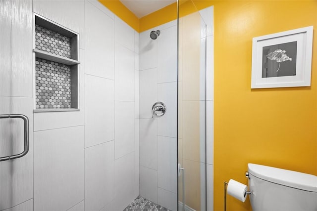 bathroom featuring a shower stall and toilet