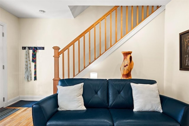 living room featuring stairs, baseboards, and wood finished floors