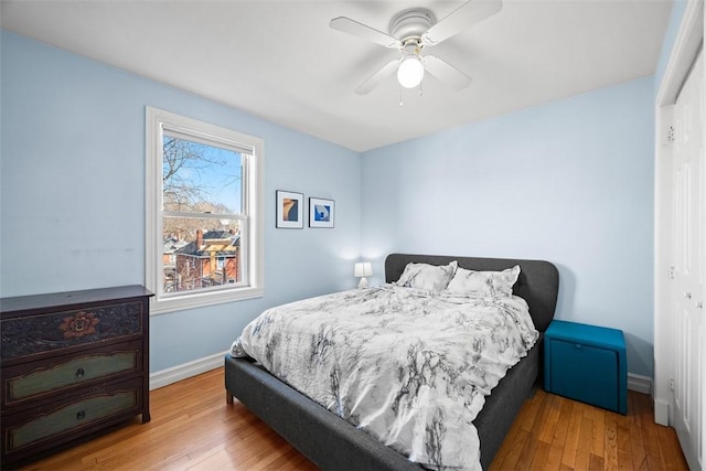 bedroom with hardwood / wood-style flooring, baseboards, and a ceiling fan