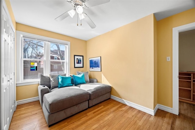 sitting room with light wood-type flooring, ceiling fan, and baseboards