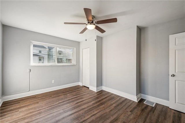 unfurnished bedroom with a ceiling fan, wood finished floors, visible vents, and baseboards