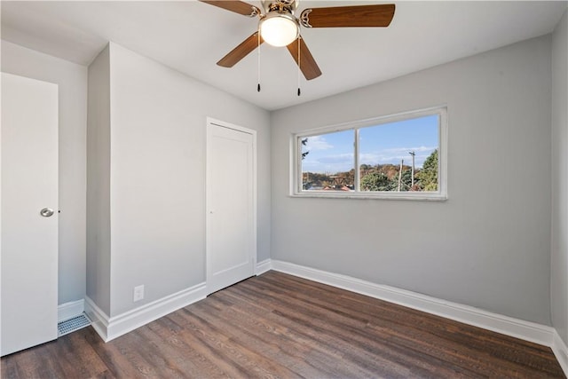 empty room with a ceiling fan, baseboards, and wood finished floors