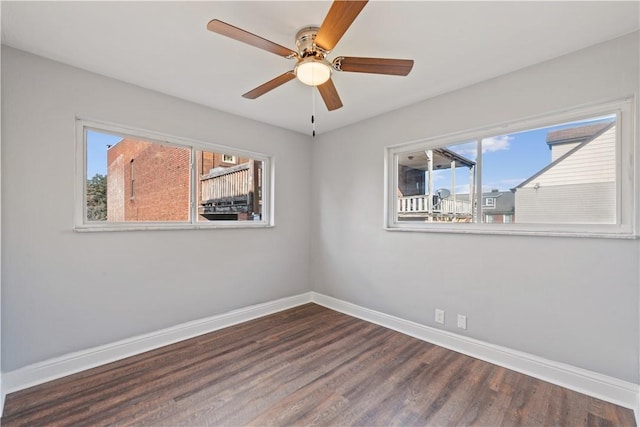 empty room featuring baseboards, wood finished floors, and a ceiling fan