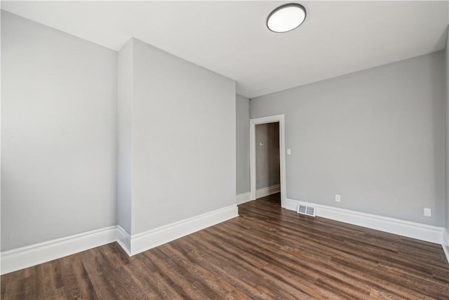 empty room with visible vents, baseboards, and wood finished floors