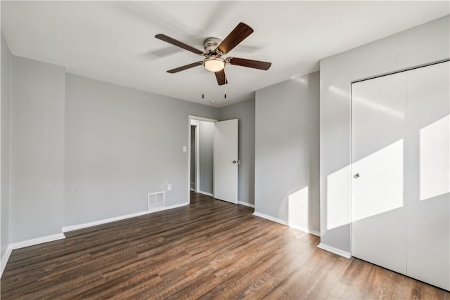 empty room featuring visible vents, baseboards, wood finished floors, and a ceiling fan