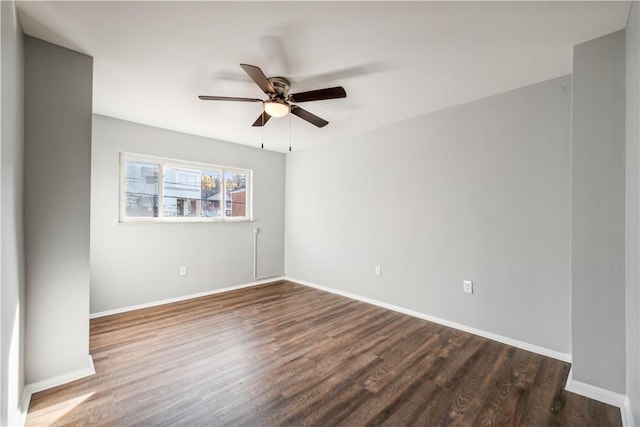 unfurnished room with baseboards, ceiling fan, and dark wood-style flooring