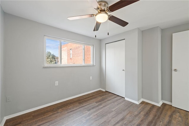 unfurnished bedroom with a ceiling fan, wood finished floors, baseboards, and a closet