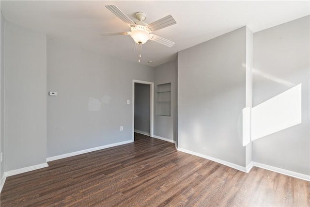 spare room with ceiling fan, baseboards, and wood finished floors