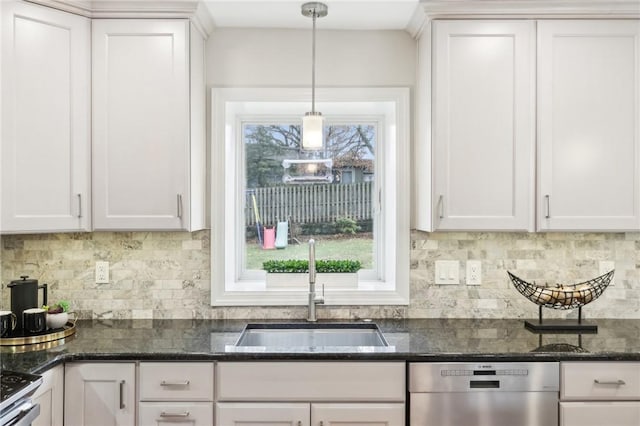 kitchen featuring dark stone counters, appliances with stainless steel finishes, a sink, and white cabinets