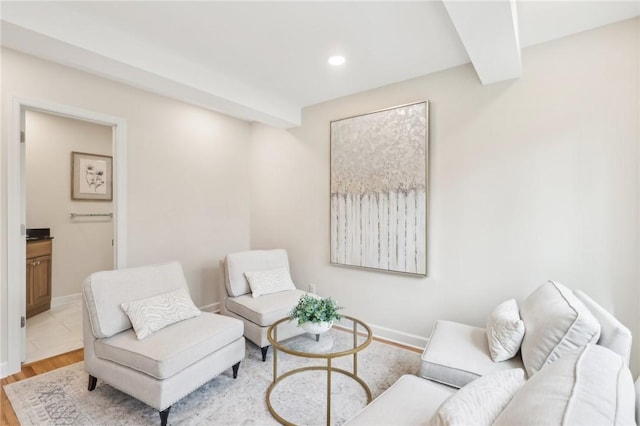 living area with recessed lighting, beam ceiling, baseboards, and wood finished floors