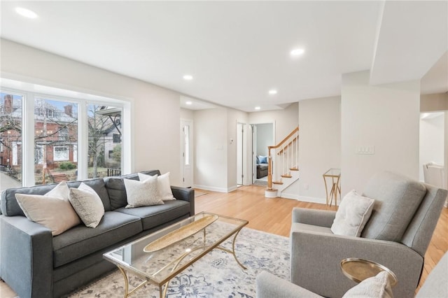 living area featuring light wood-style floors, recessed lighting, baseboards, and stairs