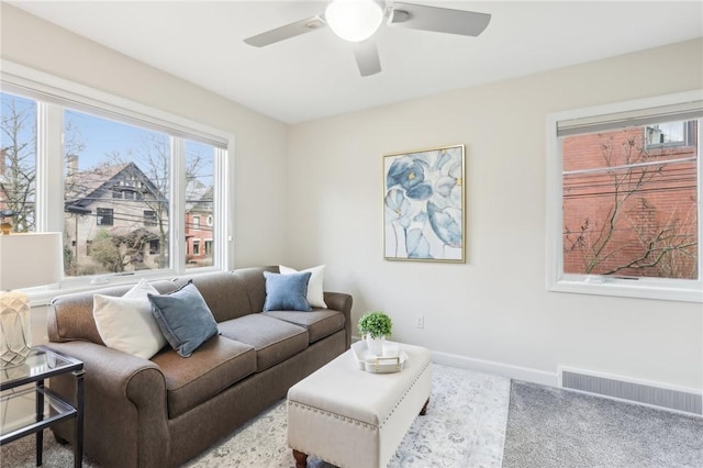 living area with visible vents, ceiling fan, and baseboards