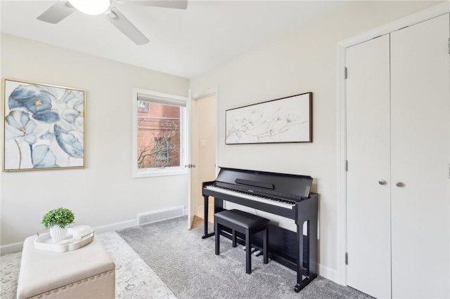 living area with a ceiling fan, carpet, visible vents, and baseboards