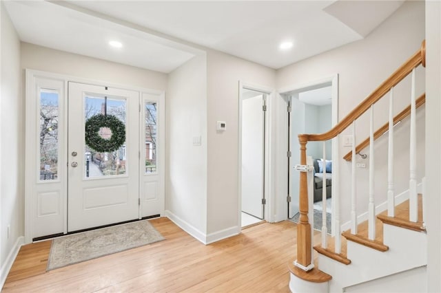 foyer entrance featuring light wood-type flooring, stairway, baseboards, and recessed lighting