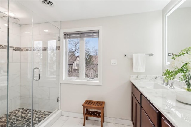 full bathroom with double vanity, a shower stall, visible vents, and a sink