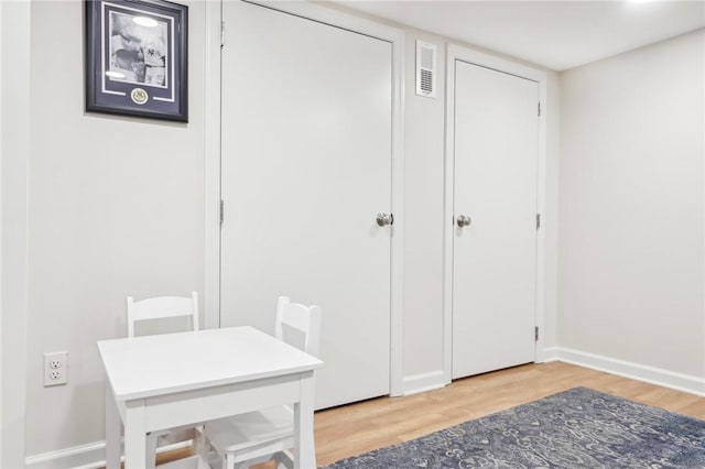 interior space with visible vents, baseboards, and wood finished floors