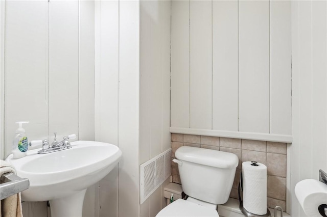 bathroom featuring toilet, visible vents, and a sink