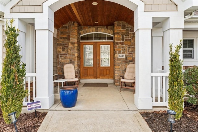 doorway to property featuring stone siding and french doors