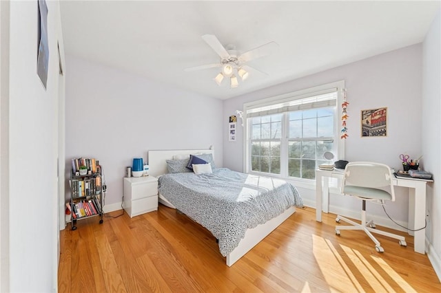 bedroom with light wood-type flooring, ceiling fan, and baseboards