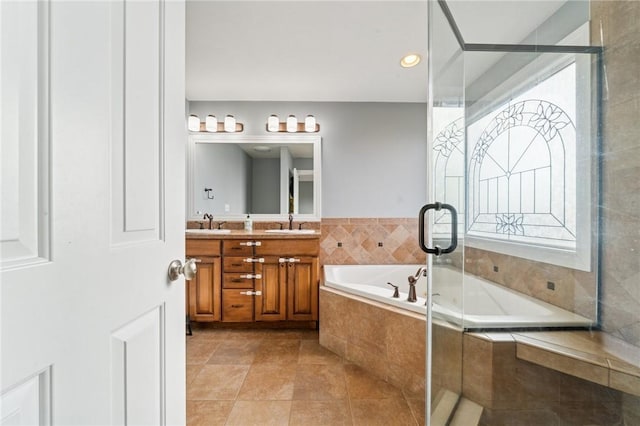 bathroom featuring a sink, a shower stall, a bath, and double vanity