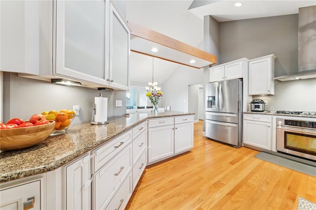 kitchen with light wood-style floors, vaulted ceiling with beams, stainless steel appliances, wall chimney range hood, and white cabinetry