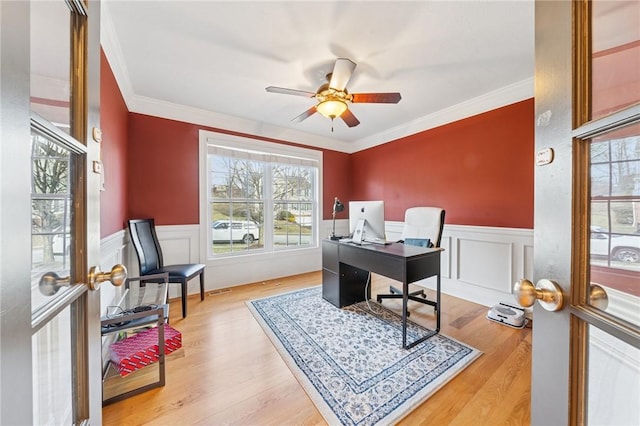 office space with wainscoting, crown molding, and wood finished floors