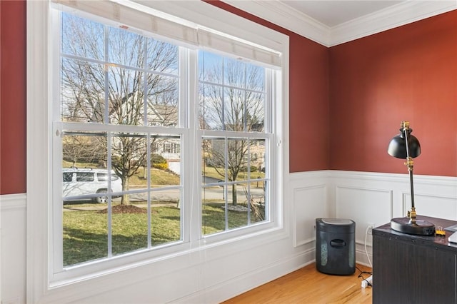 office area featuring a wainscoted wall, plenty of natural light, ornamental molding, and wood finished floors