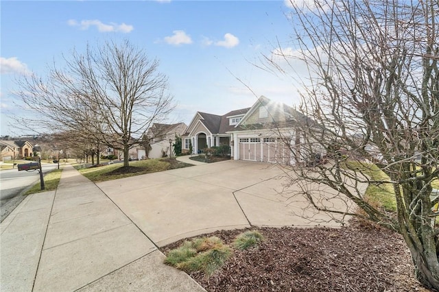 view of front of house with a residential view, concrete driveway, and an attached garage