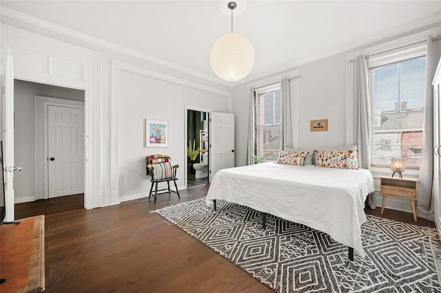 bedroom featuring dark wood-style flooring, crown molding, and baseboards