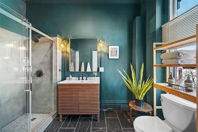 bathroom featuring toilet, marble finish floor, vanity, and a stall shower